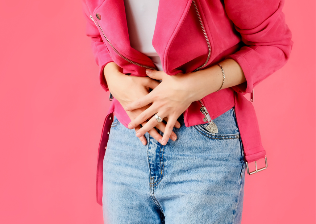 Foto einer Frau, die sich gekrümmt den Bauch hält. Bauchschmerzen sind typische Beschwerden bei Verdauungsproblemen.
