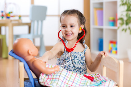 Kindern spielerisch die Einnahme von Medikamenten mit einer Babypuppe erklären 