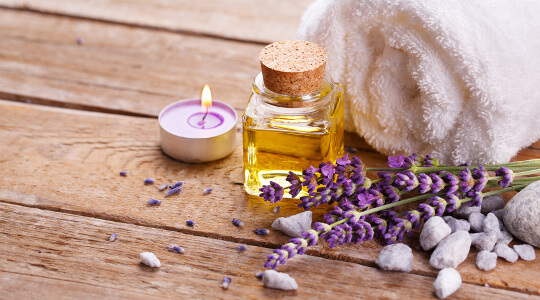 Aromatherapie: Teelicht, ätherisches Öl, Handtuch und Lavendel.